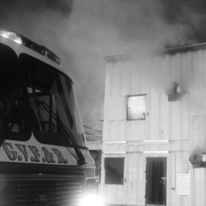 Fire truck in front of burn building at night